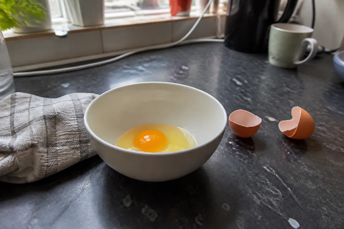 A cracked egg on a kitchen worktop