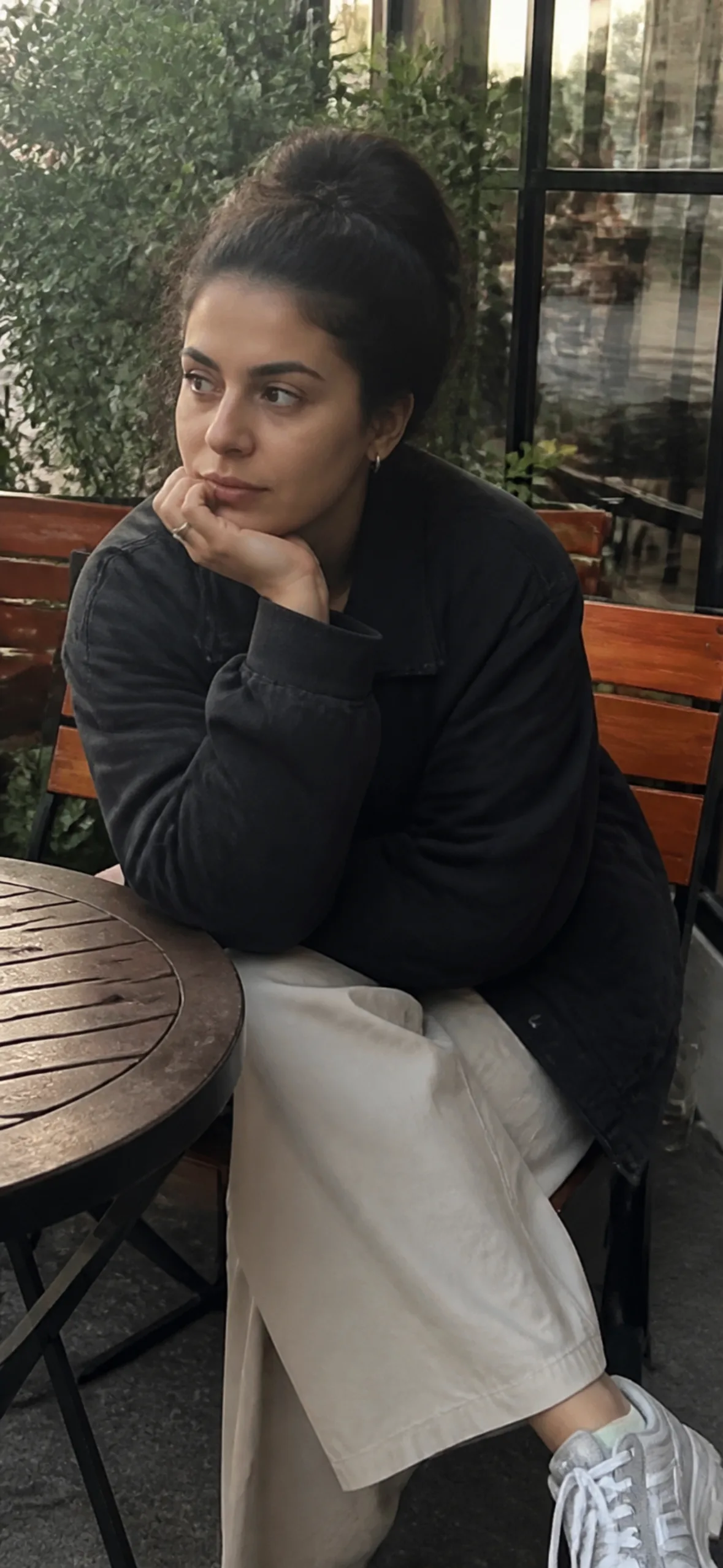 iPhone lock screen wallpaper — woman sitting outside a cafe