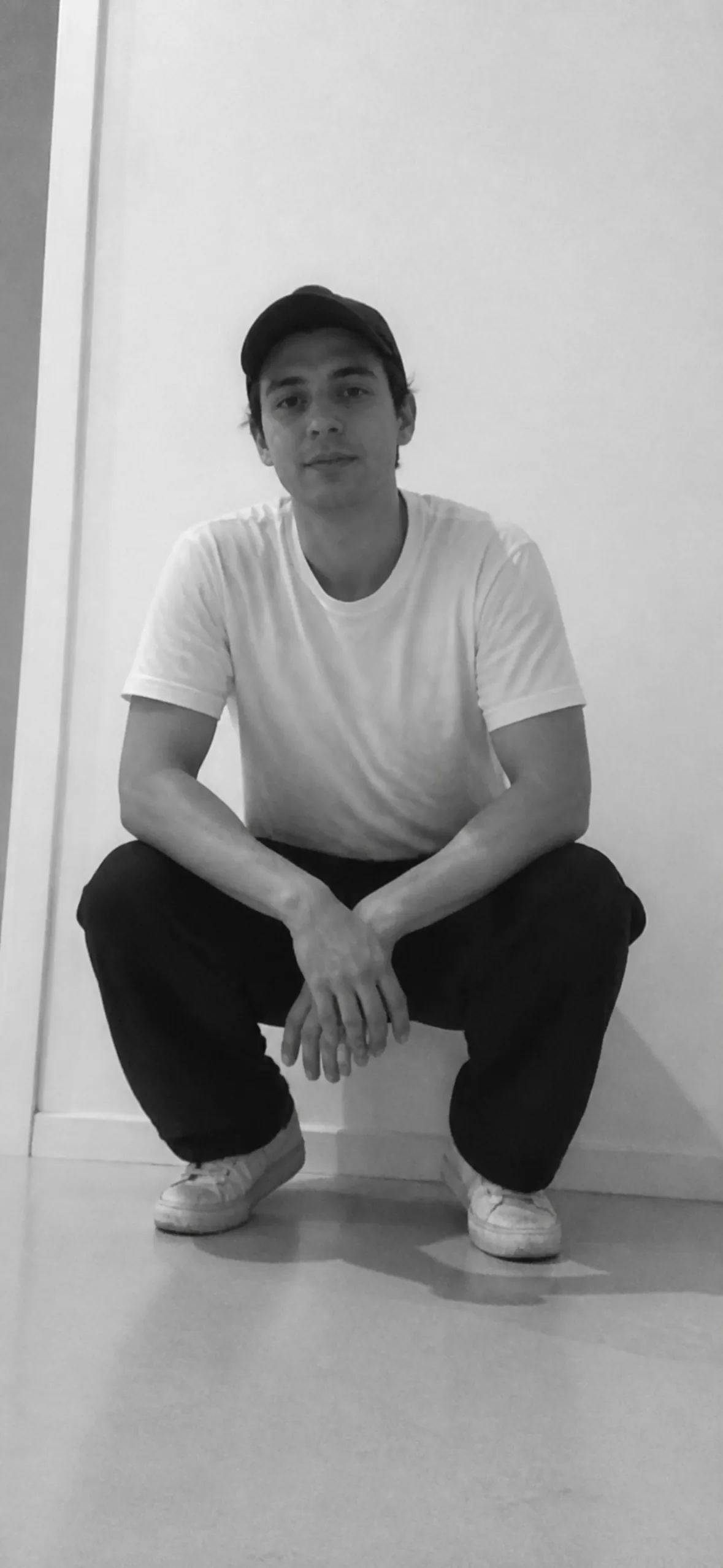 iPhone lock screen wallpaper — black and white photo of a man crouching