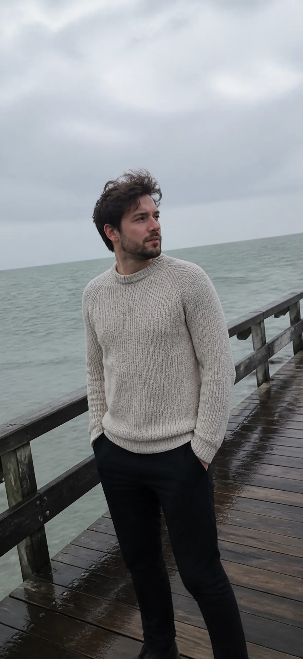 4k phone wallpaper — man in a fisherman sweater on a windswept pier